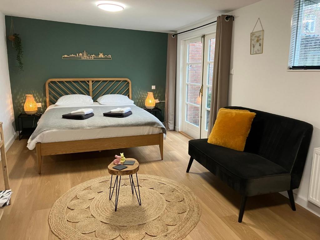 a bedroom with a bed and a chair and a table at De Haarlemse Logeerkamer in Haarlem