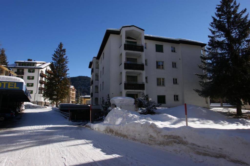 une rue enneigée devant un bâtiment dans l'établissement Landwasser, à Davos