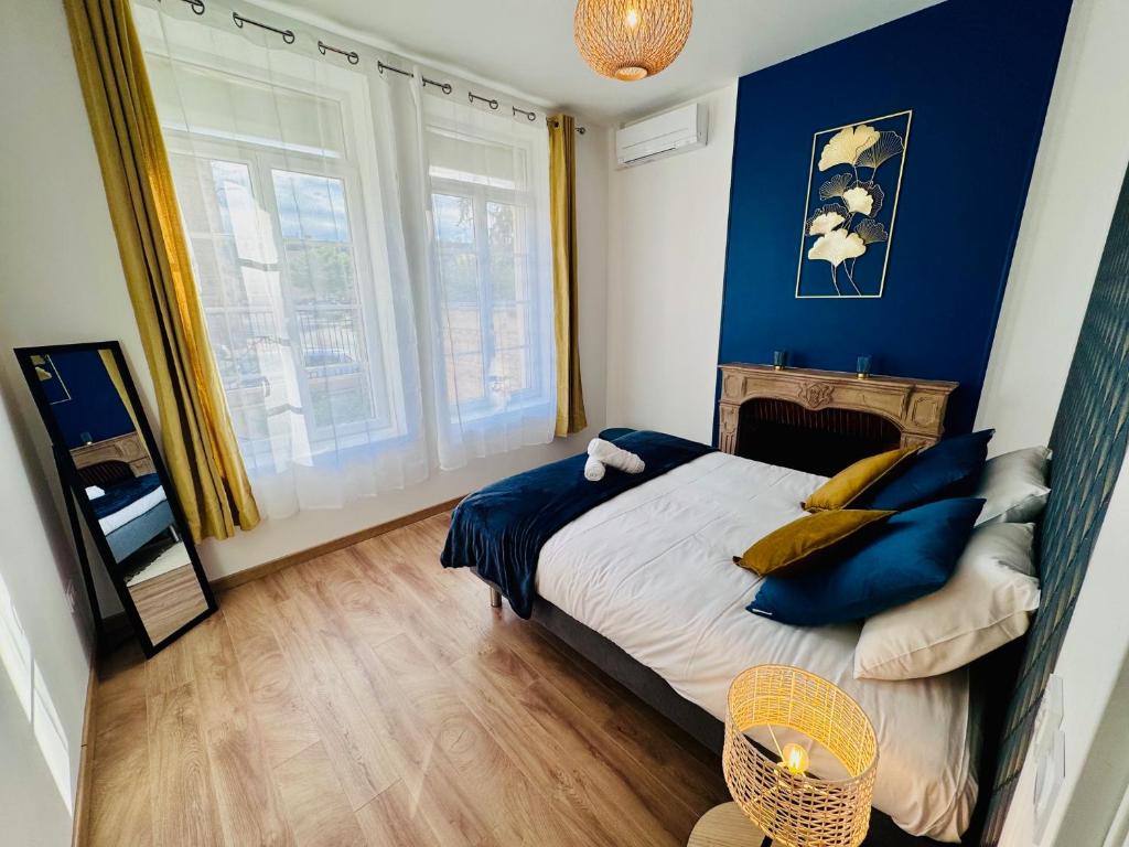 a bedroom with blue walls and a bed with blue pillows at Chaleureux T2 proche gare in Bourgoin