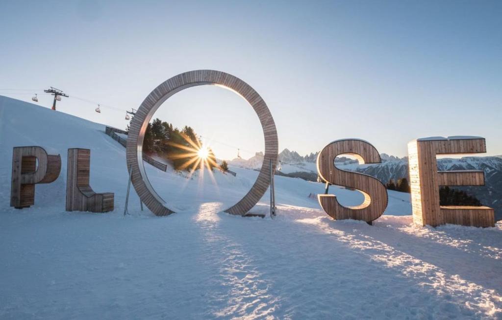 um sinal na neve com o sol atrás dele em Apartment Sant'Andrea, Brixen - Plose Ski, Hike, Bike, Nature em SantʼAndrea in Monte