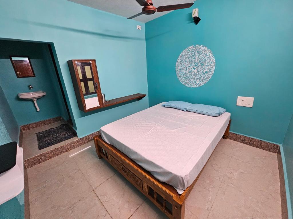 ein Schlafzimmer mit einem Bett in einem blauen Zimmer in der Unterkunft New Ananda lodge in Vriddhāchalam