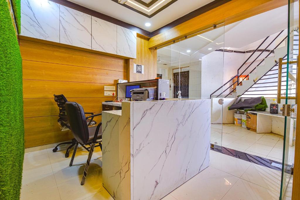 アーメダバードにあるHOTEL GREEN TREEの大理石のカウンターと椅子付きの事務所