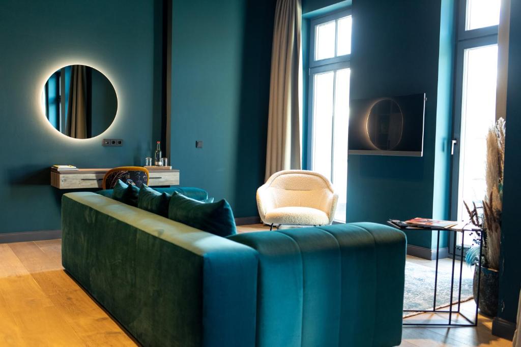 een blauwe woonkamer met een bank en een spiegel bij Hotel Atlantic in Westerland