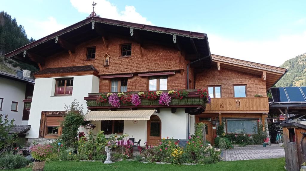 une maison avec des fleurs devant elle dans l'établissement Landhaus Rasser, à Rauris