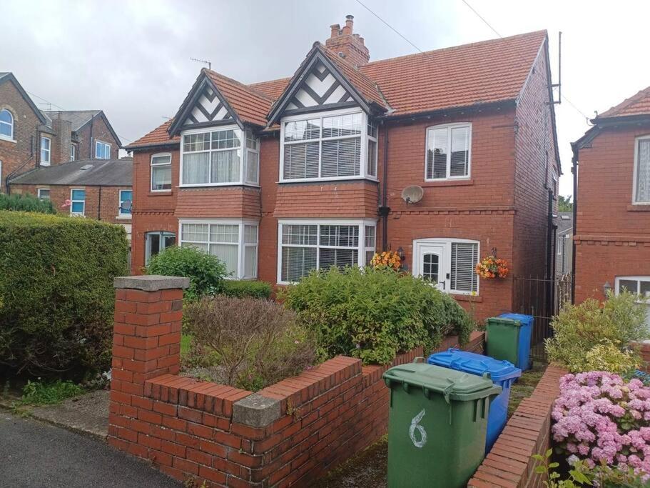 a brick house with two trash cans in front of it at 7 Cromwell Gardens - 2 Bed House in Scarborough