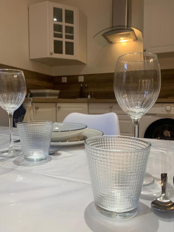 une table avec trois verres à vin en haut dans l'établissement Charmant appartement, à Saint-Claude