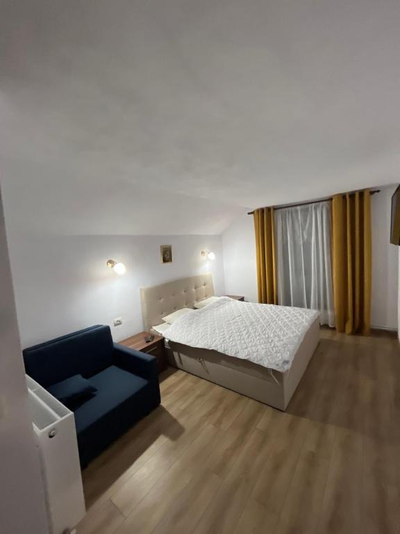 a bedroom with a bed and a couch at Pensiunea Sarah - Muntele Mic in Muntele Mic