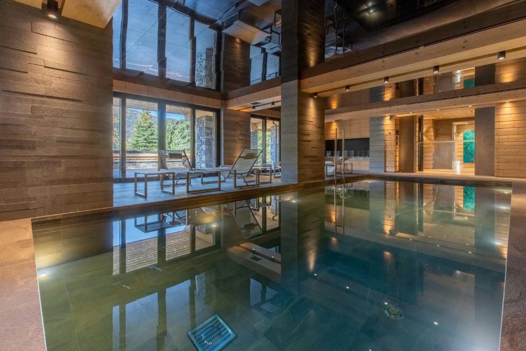 an indoor swimming pool in a house with a large room at Chalet Le Nolde in Mussillon