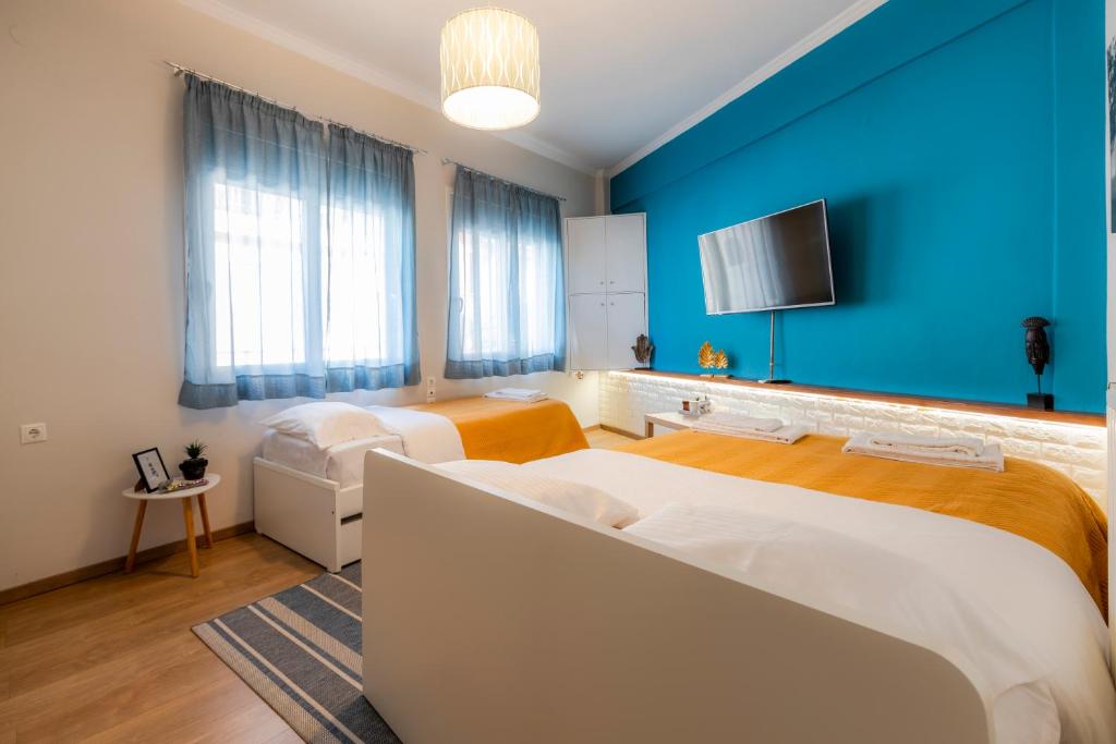een slaapkamer met 2 bedden en een blauwe muur bij Korte Apartment 1 in Árta