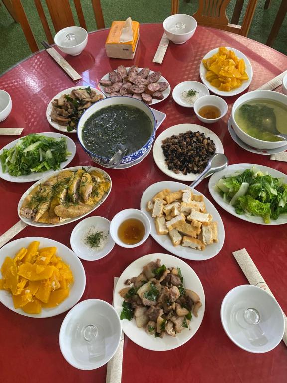 una mesa roja con platos de comida. en Mai Anh Homestay - Pac Bo Village, 