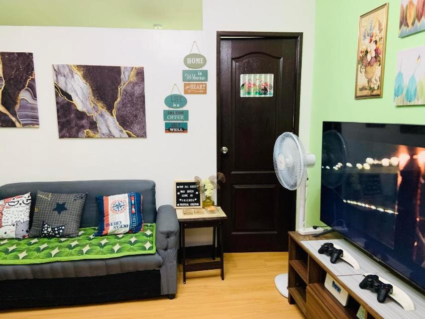 ein Wohnzimmer mit einem Sofa und einem Flachbild-TV in der Unterkunft Condo staycation in Marilao in Marilao