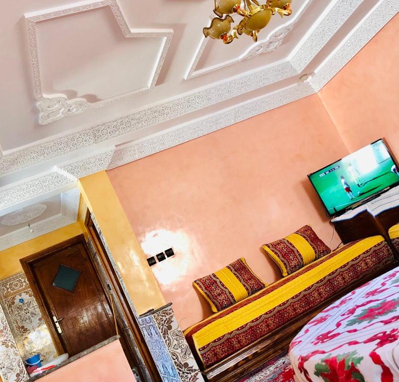 a room with a bed and a flat screen tv at Zino house in Khouribga