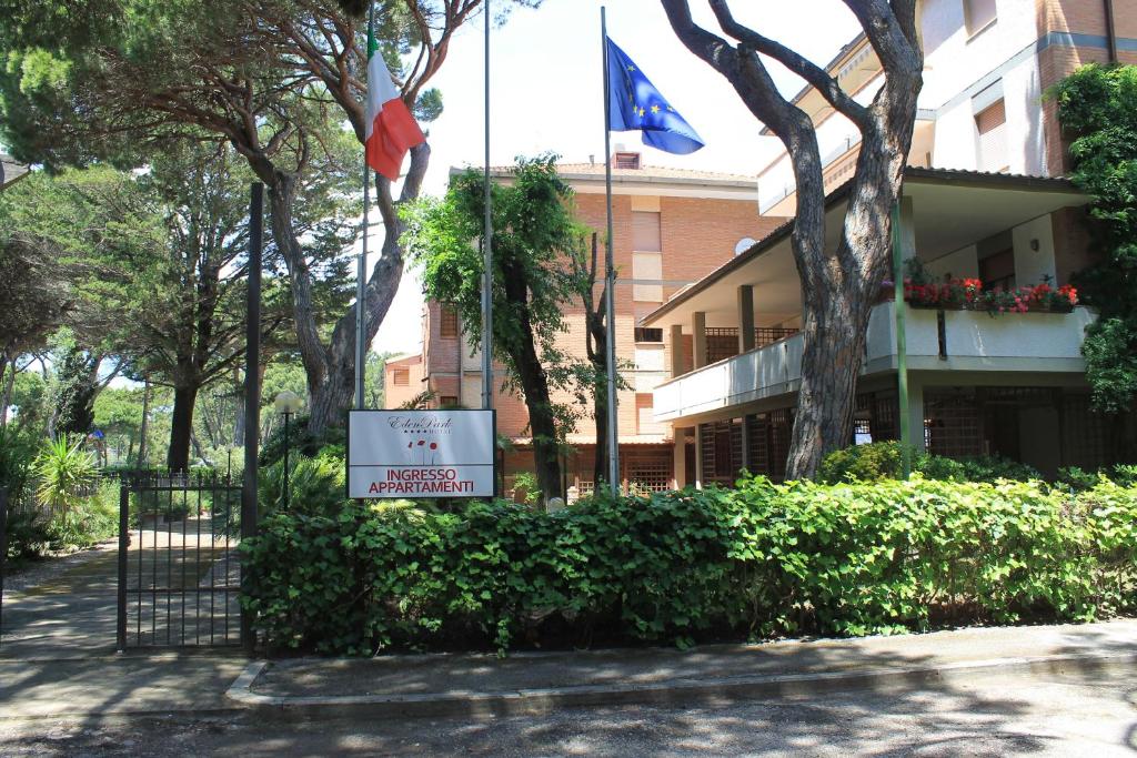 een gebouw met een vlag en een bord ervoor bij Eden Appartamenti in Marina di Grosseto