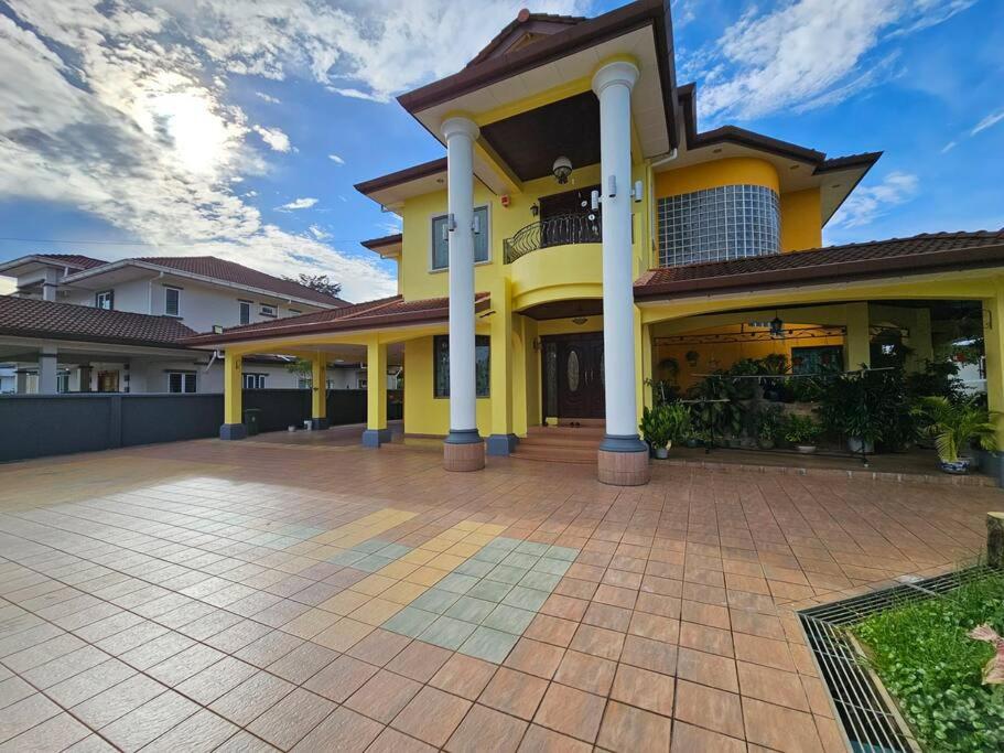 Una gran casa amarilla con una gran entrada en Lovely Luxury Detached House Vivacity Kuching en Kuching
