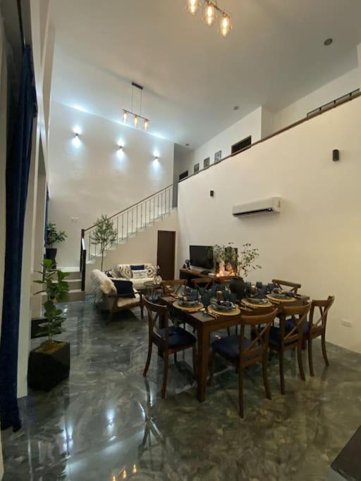 uma sala de jantar com uma mesa e cadeiras numa sala de estar em New Uniquely-Designed House em Dumaguete