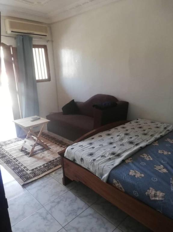 sypialnia z łóżkiem i kanapą w pokoju w obiekcie Buzsahm w mieście Dakar