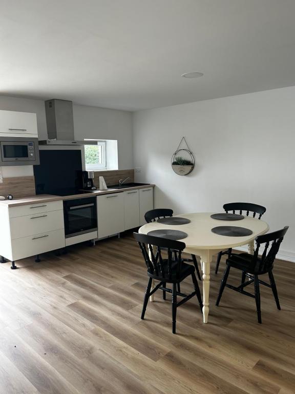 a kitchen and dining room with a table and chairs at Petite maison in Plouguerneau