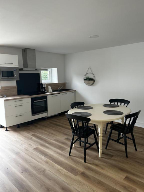 - une cuisine et une salle à manger avec une table et des chaises dans l'établissement Petite maison, à Plouguerneau