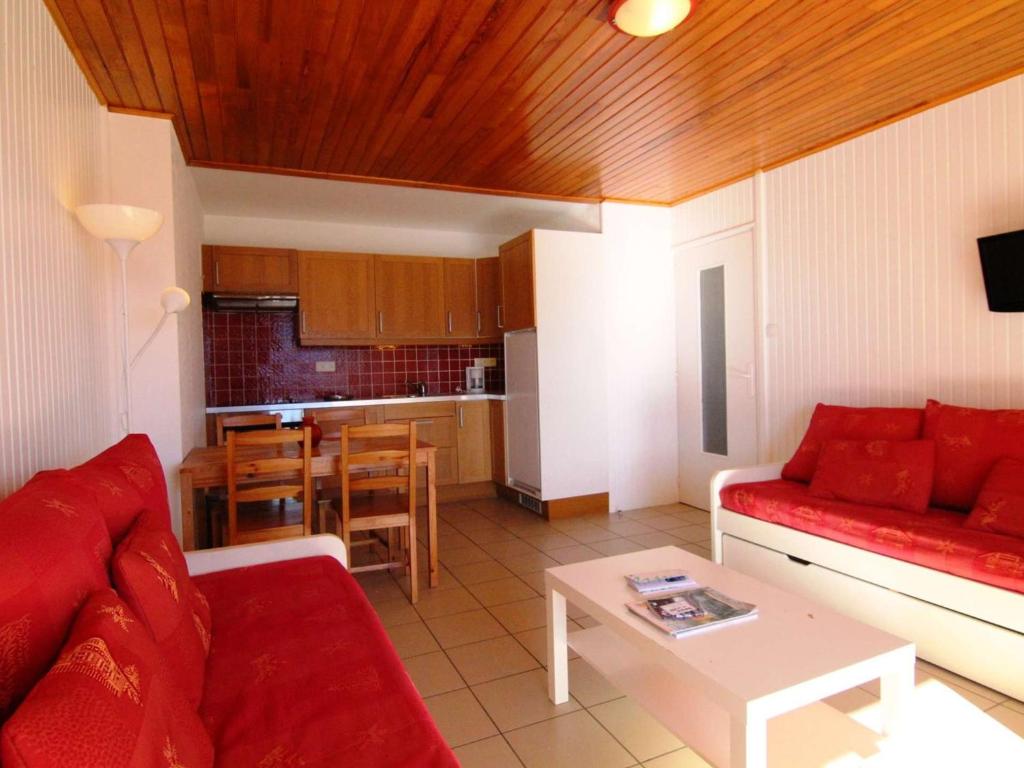 a living room with a red couch and a table at Appartement 2 pièces, 5 pers, ski aux pieds, Wi-Fi, animaux admis - Vieil Alpe - FR-1-405-153 in L'Alpe-d'Huez