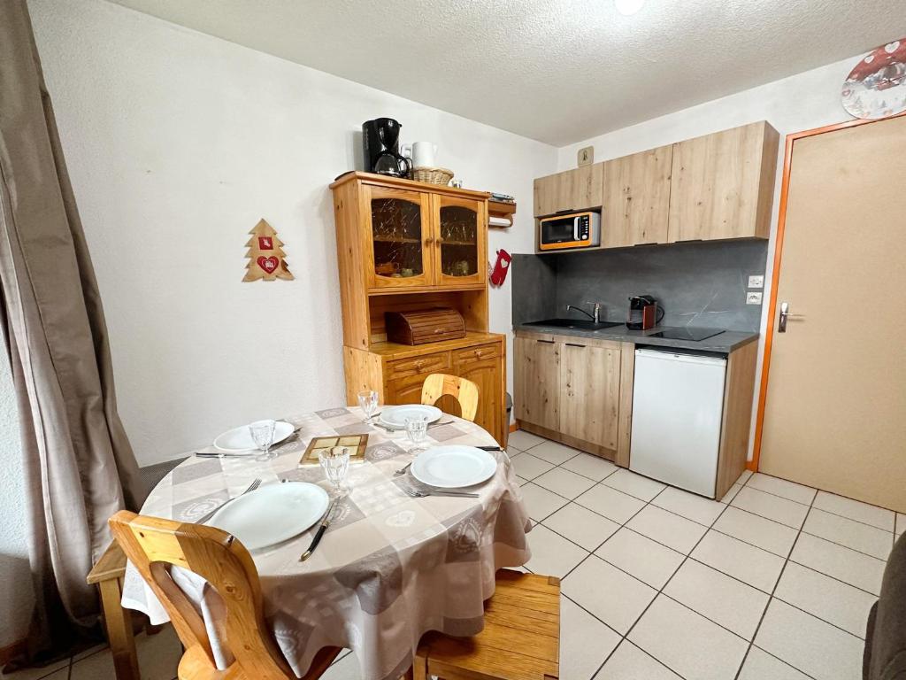 una cucina con tavolo, sedie e tovaglia bianca di Studio Samoëns, 1 pièce, 4 personnes - FR-1-624-115 a Samoëns