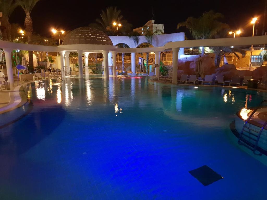a swimming pool at night with blue illumination at De Golf Luxury Resort Apartments in Eilat
