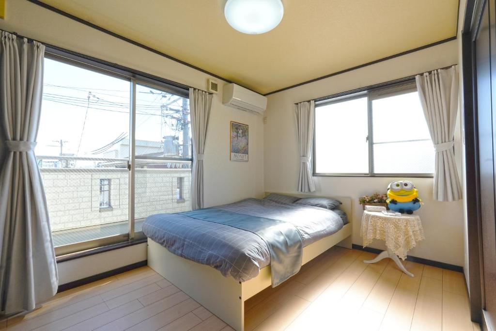 una camera con un letto e due grandi finestre di Maple Hotel Osaka ad Osaka