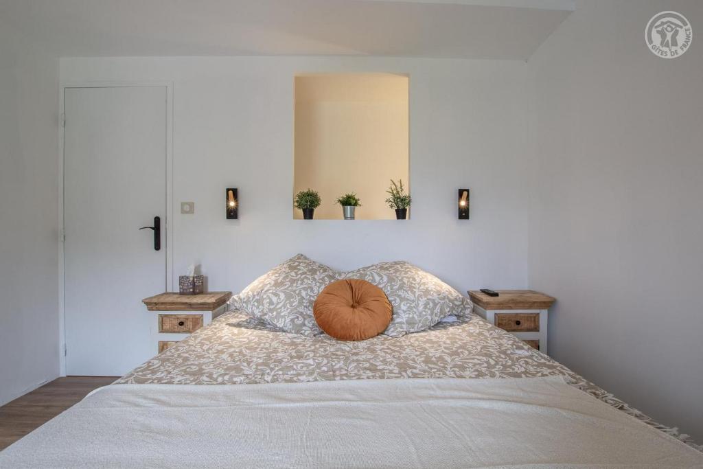 a bed with a pumpkin pillow on top of it at La cigale et la fourmi savoisienne - gîtes in Aix-les-Bains