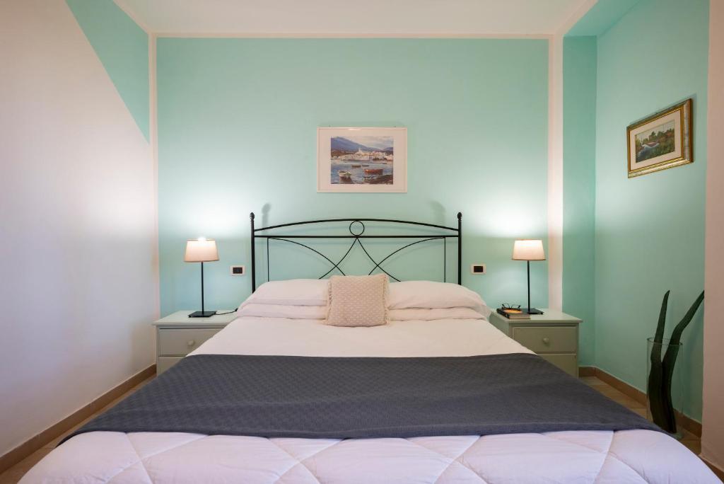 a bedroom with a large bed with two lamps at Ombra Verde Residence e B&B in Follonica
