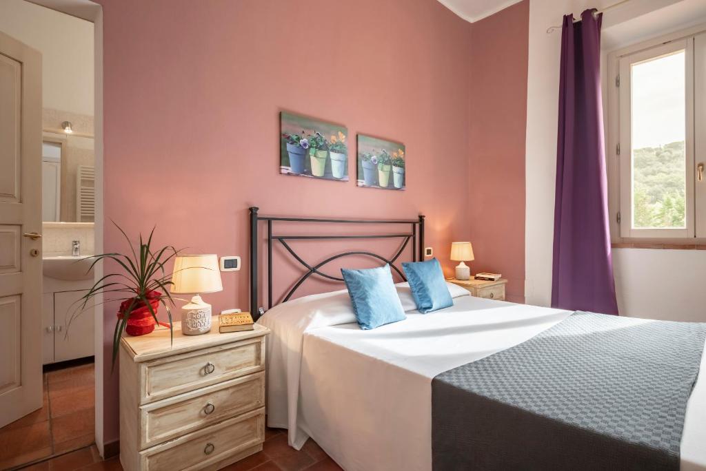 a bedroom with a bed with blue pillows on it at Ombra Verde Residence e B&B in Follonica
