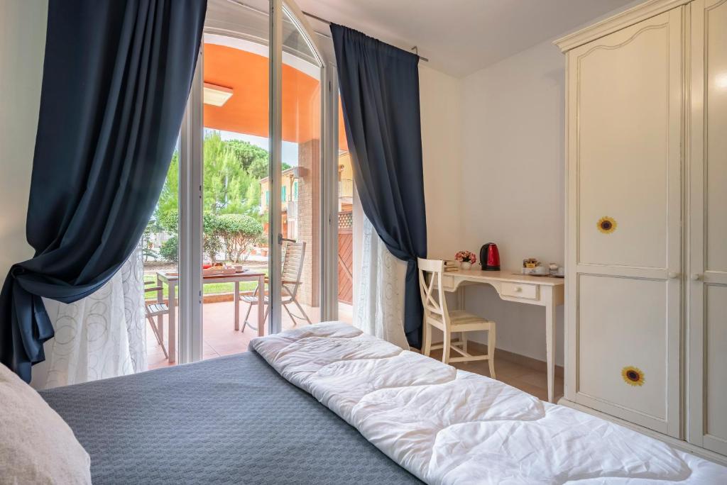 a bedroom with a bed and a view of a patio at Ombra Verde Residence e B&B in Follonica