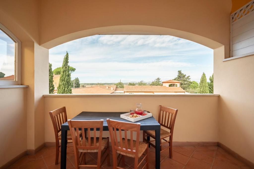 a dining room with a table and chairs and a window at Ombra Verde Residence e B&B in Follonica