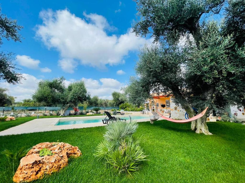 een tuin met een hangmat naast een zwembad bij All'ombra degli Ulivi by BarbarHouse in Latiano