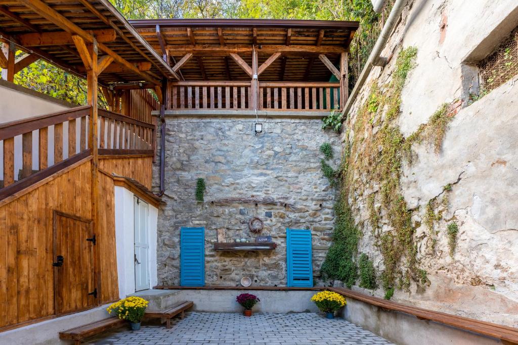 a building with blue doors and a stone wall at Casa Maya Transilvania in Sighişoara