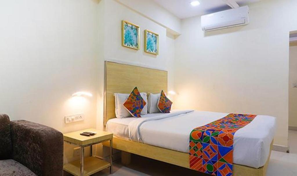 a hotel room with a bed and a couch at FabHotel Swarnas in Vijayawāda
