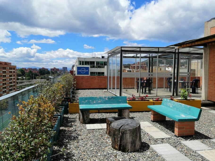 un patio con bancos y un edificio de cristal en Bien ubicado, cómodo y funcional, en Bogotá