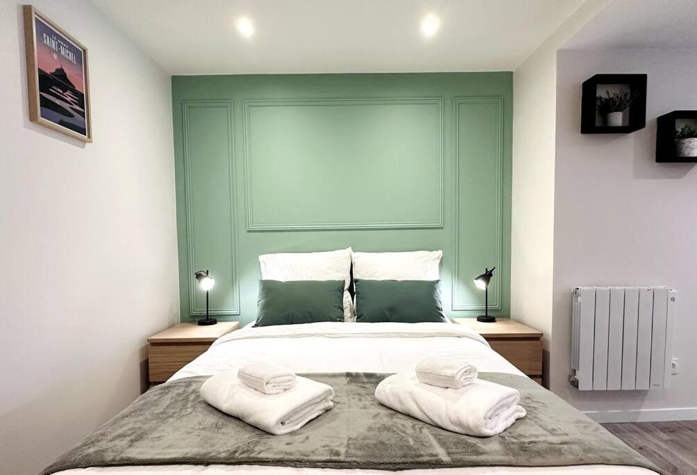 una camera da letto con un grande letto con due asciugamani di L'Escale du Mont Saint Michel ad Avranches