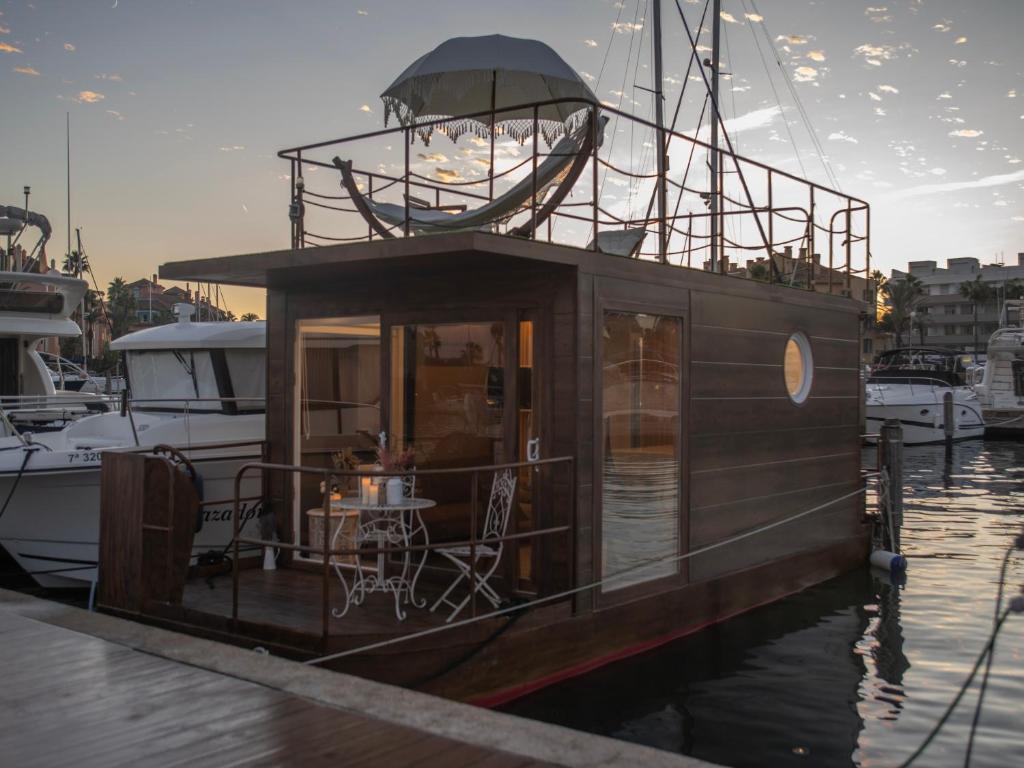 een kleine boot is aangemeerd in het water bij La Maison de la Mer Sotogrande in Sotogrande