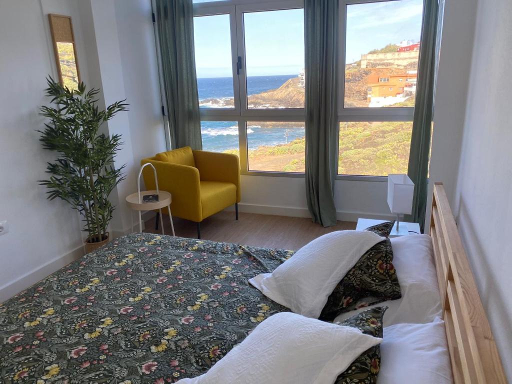 ein Schlafzimmer mit einem Bett, einem Stuhl und einem Fenster in der Unterkunft El Apartamento de Margot in Las Toscas