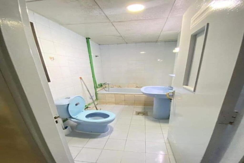 a bathroom with a blue toilet and a sink at Single Room Near "World Trade Centre&Beach" Abudhabi in Abu Dhabi