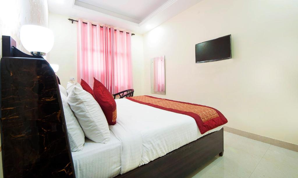 a bedroom with a bed with a tv on the wall at Hotel Jiva Banquet in New Delhi