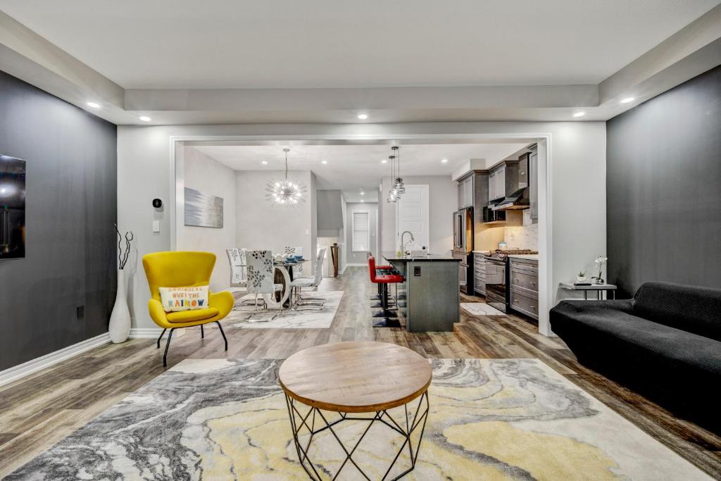 a living room with a table and a yellow chair at Modern Family Friendly 4BR Home Away From Home in Milton