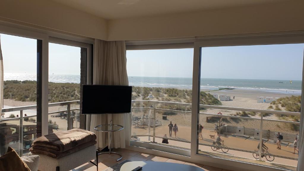 a living room with a view of the beach at Zeemeermin in Nieuwpoort