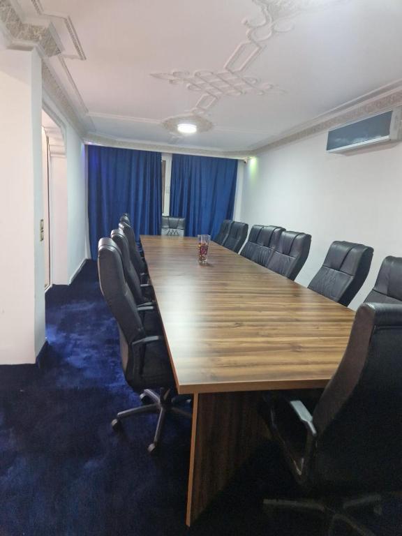 centre d'affaire في Zemmour Touirza: قاعة المؤتمرات مع طاولة وكراسي خشبية طويلة