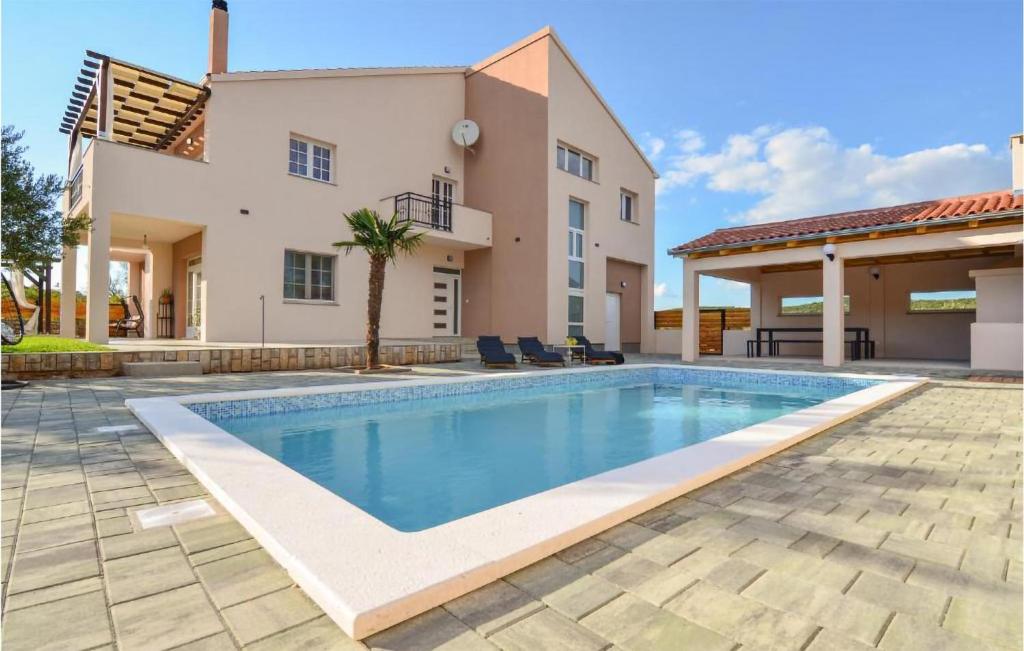 - une piscine en face d'une maison dans l'établissement Amazing Apartment In Kasic With Wifi, à Kašić