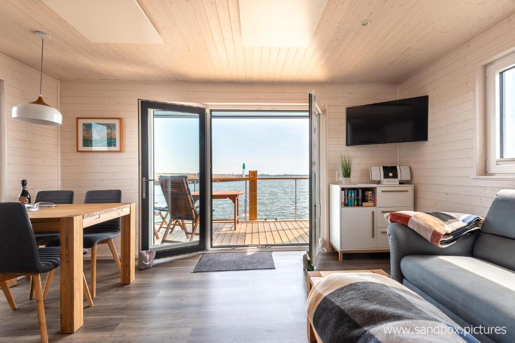 uma sala de estar com um sofá e uma mesa em Hausboot Harmonie em Stralsund