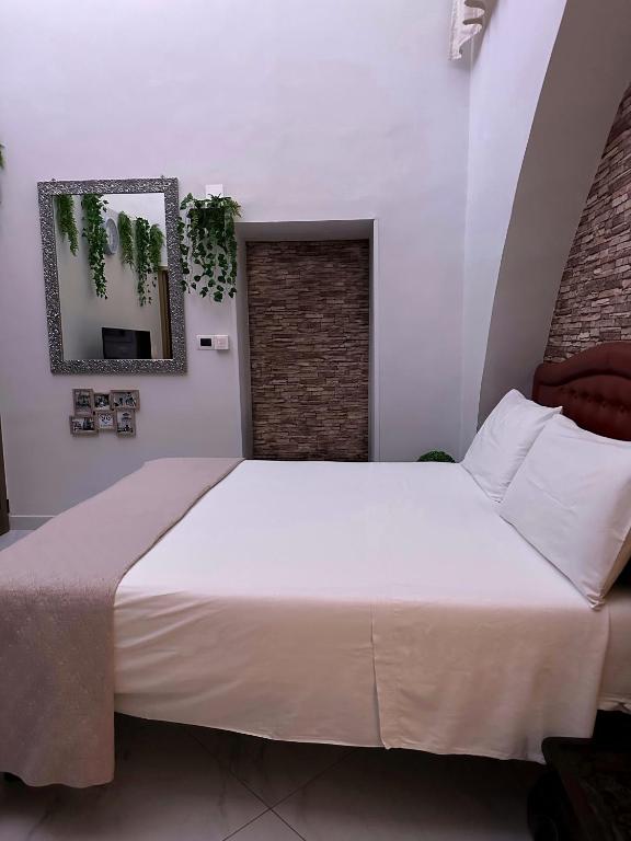 1 dormitorio con 1 cama grande con sábanas blancas en Vi Luxury Room en Pagani