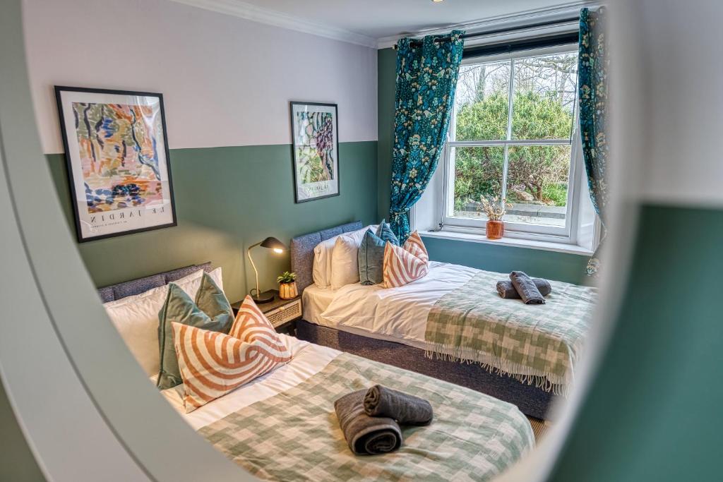 um quarto com duas camas e uma janela em 2 Bed Stylish Spacious Apt -Sleeps 6 Central Cheltenham, with Free Parking - By Blue Puffin Stays em Cheltenham