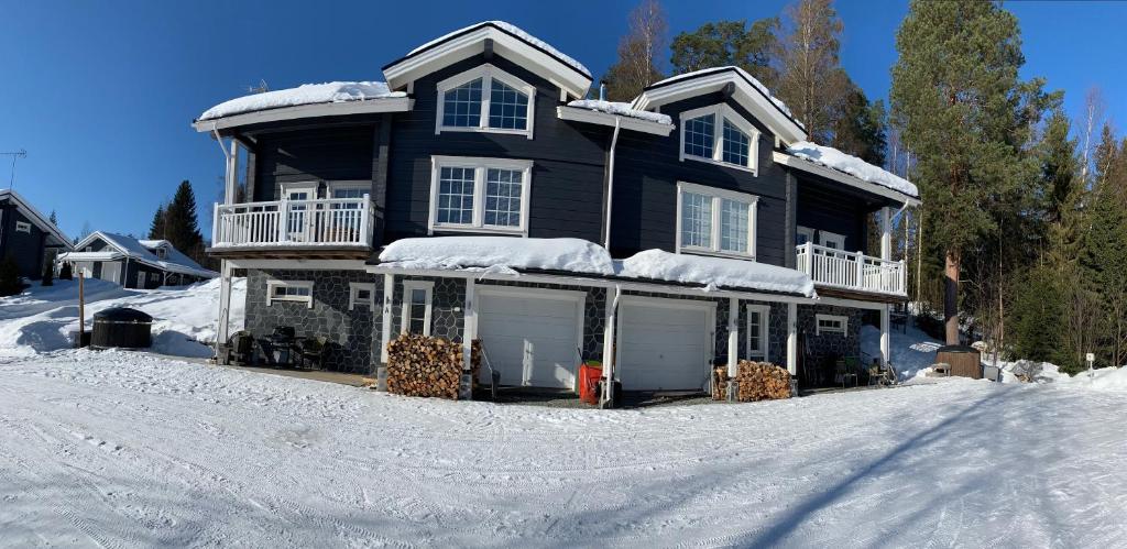 una casa grande con nieve en el suelo en Holiday Home Kerssintie, en Tahkovuori