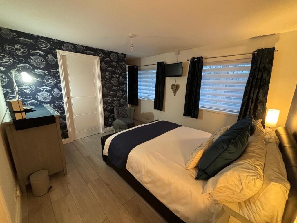 a bedroom with a bed and a desk and window at Craster Crew House in Craster