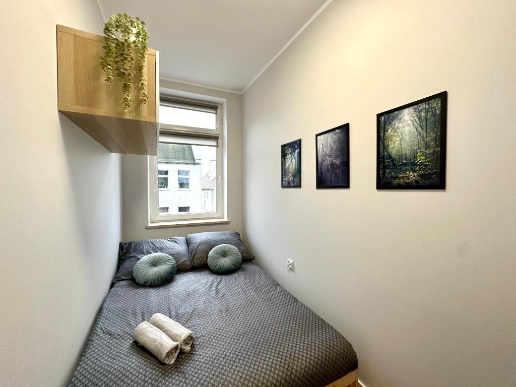 a room with a bed with pillows and a window at Forest Room in Gdańsk